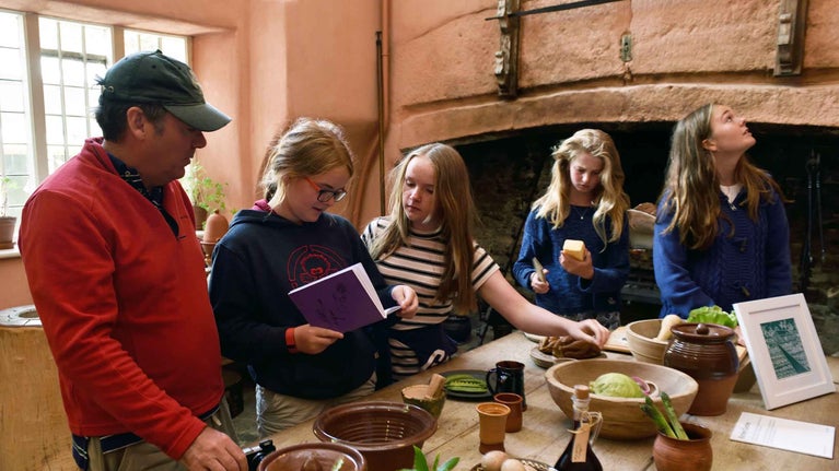 Family exploring the kitchen displays at Buckland Abbey, Devon